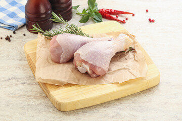 Raw chicken leg over board