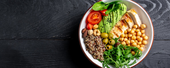 Buddha bowl with kale salad, quinoa, chicken fillet, chickpeas, avocado, spinach, tomatoes cherries, nuts arugula, Clean eating, dieting food concept. Long banner format. top view