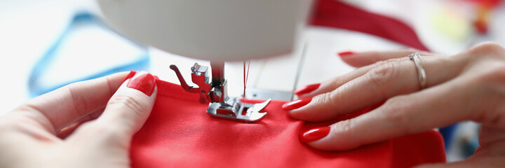 Hands with manicure repairing clothes of clients