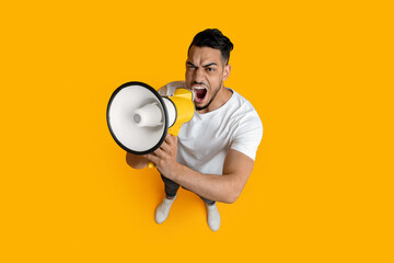 Top view of furious middle eastern guy with loudspeaker