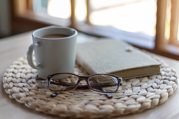 cup of coffee, notebook and eyeglasses