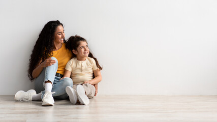 Family Advertisement. Happy Mom And Little Daughter Looking Aside At Copy Space