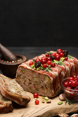 Fototapeta na wymiar Traditional French terrine covered with bacon on dark wooden background