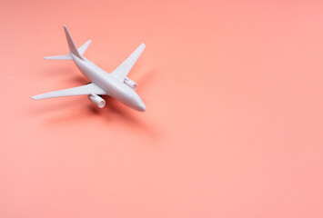 White clean Plane model on pastel pink color background with copy space, minimal style. White airplane, close up. Flight, travel concept.