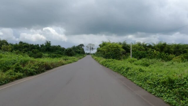 Driving Rural village forest jungle Liberia Africa road block POV. Coast of west Africa extreme poverty and hunger. Rubber plantation. Tropical climate. Civil war destroyed the economy.