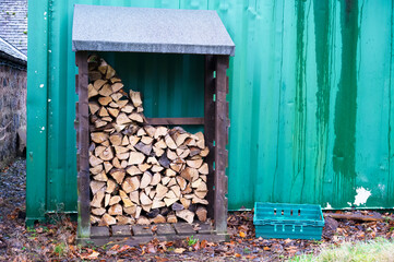 Chopped wood logs for sale use in fire place at home stored on forest woods green biomass energy