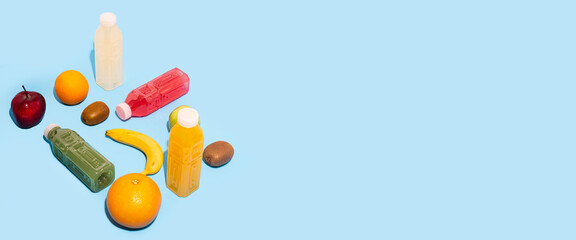 Fruits, juices detox in plastic bottles on a blue background. Banner.