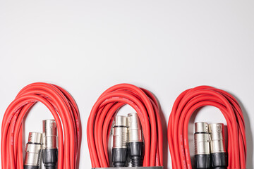 Red microphone cables bundled on white background