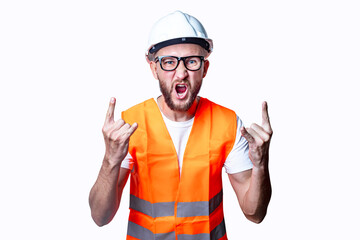 Young male construction worker showing rocker goat sign on light background.