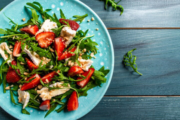 Healthy dish. Salad strawberry, aragula and brie, camembert cheese. Concept vegan and healthy eating. Top view. Diet dinner or lunch menu