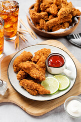 Delicious crispy fried breaded chicken breast strips with ketchup.	