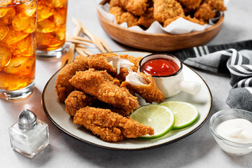 Delicious crispy fried breaded chicken breast strips with ketchup.	