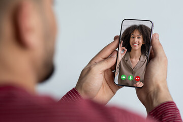 Fototapeta premium Unrecognizable guy using smartphone, having online party with girlfriend