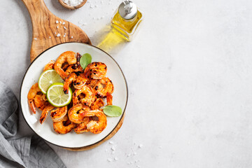 Grilled tiger shrimps with spice and lime. Light gray background, top view. Space for text	