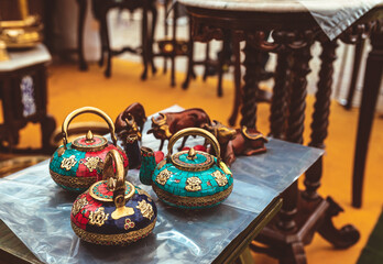 traditional indian colourful tea pots on display at a store.