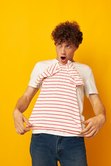 cute red-haired guy in a white t-shirt holds a striped t-shirt fashion youth style isolated background unaltered