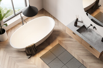 Top view of light bathroom interior with bathtub and window with countryside