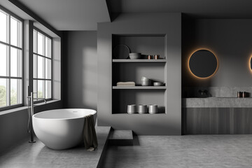 Fototapeta na wymiar Dark bathroom interior with bathtub, sink and shelf with decoration, window