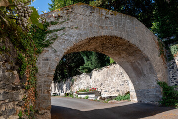 Fototapeta na wymiar Vieille arche de pierre servant de mur d'enceinte dans un vieux village en Auvergne
