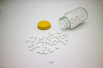 薬瓶からこぼれた白い錠剤、白背景 4
White tablets, medicaments, pills spread from the bottle on the white surface.