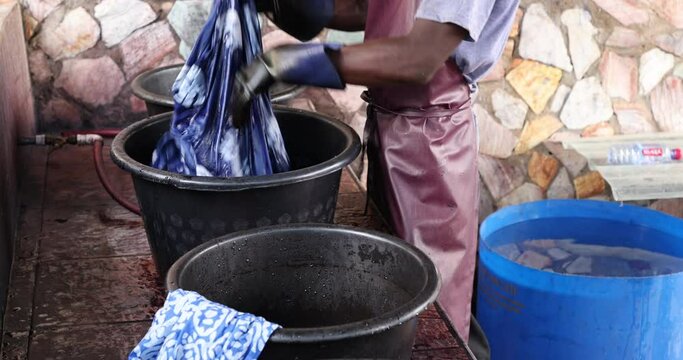 Batik fabric dye vats handmade material Accra Ghana. Local neighborhood fabric clothing manufacturing craft center. Ghanaian family makes, teaches and instructs in the traditional African printing.
