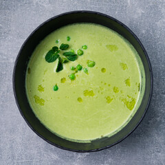 Fresh green pea soup bowl on gray concrete background