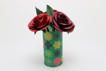 折り紙で作ったバラの花をカラフルなグラスに飾った様子
