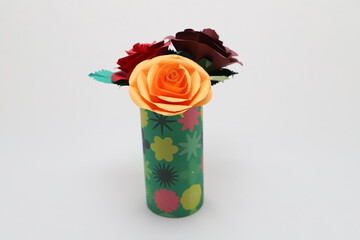 折り紙で作ったバラの花をカラフルなグラスに飾った様子