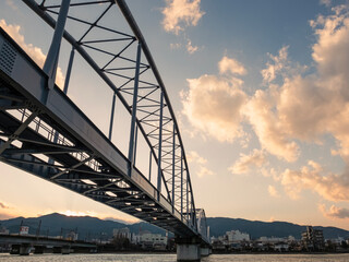 Fototapeta premium 色づいた夕暮れの琵琶湖瀬田川にかかる 瀬田川共同橋