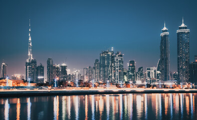 Obraz premium DUBAI, UAE - FEBRUARY 2018: Colorful sunset over Dubai Downtown skyscrapers and the newly built Tolerance bridge as viewed from the Dubai water canal.
