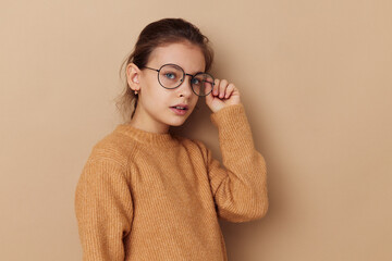 pretty young girl in a sweater and posing glasses childhood unaltered