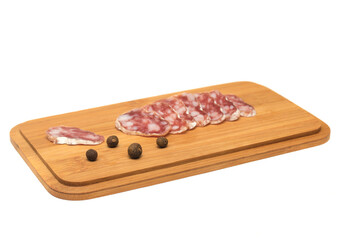 Smoked sausage cut on a wooden board with peppers isolated on white background