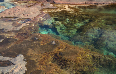 Fototapeta na wymiar Gran Canaria, calm natural seawater pools under the steep cliffs of the north coast and separated from the ocean by volcanic rocks, Sardina del Norte area in Galdar municipality 