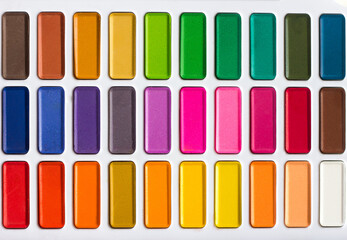 Palette of bright multi-colored watercolors close-up, artist's tools all colors of the rainbow, selective focus	