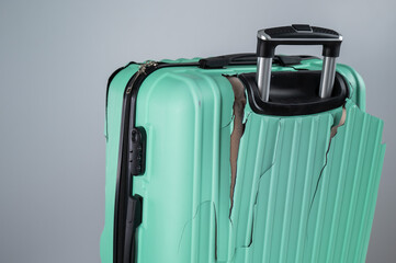 Close-up of a broken plastic suitcase on a white background.