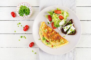Breakfast. Omelette with tomatoes, cheese, green onions and sandwich with feta cheese.  Frittata - italian omelet. Top view, above