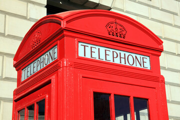 Traditional red cast iron payphone public kiosk telephone box in London England UK which is a popular travel destination tourist landmark attraction of the city, stock photo image