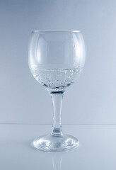 glass with mineral water and bubbles on a white background