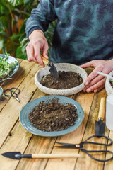 Blumentopf mit Erde befüllen, gärtnern Zuhause, Erde mit einer Schaufel in einen Topf füllen

