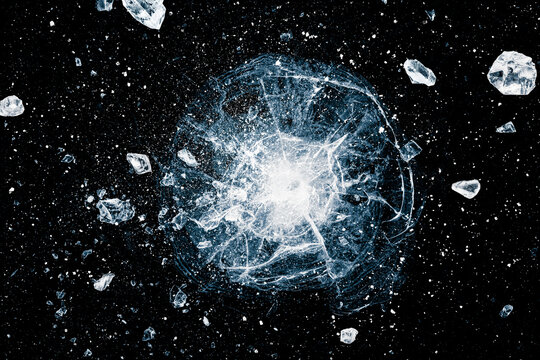 Ice, crushed on black background. Shards of crushed ice spreading away. The explosion of ice. Ice with cracks.