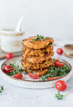 Vegetable fritters with sweet potato and herbs on gray background. Vegan food concept. vertical image, copy space