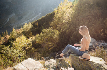 Young woman on a hiking trip sitting on a rock