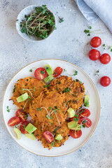 Vegan sweet potato fritters served with fresh vegetables and microgreens. Vegan alternative food. vertical image