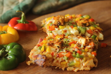 Rectangular slices of home baked pizza loaded with paneer, mozzarella cheese, red yellow green capsicums and onions