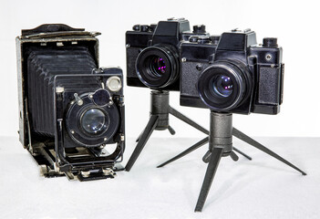 Vintage photo camera and two film reflex cameras on a white background