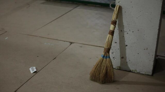 Old broom indoors, house cleaning and office.