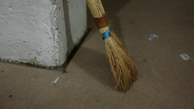 Old broom indoors, house cleaning and office.