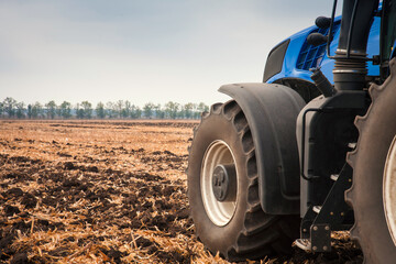 Obraz premium Modern tractor in the field during planting. The concept of agricultural industry.