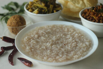 Rice porridge or Kanji along with spicy coconut red chilly chutney, stir fried boiled red cowpea beans and stir fried raw banana slices. A favourite meal of Kerala