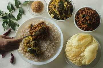 Rice porridge or Kanji along with spicy coconut red chilly chutney, stir fried boiled red cowpea beans and stir fried raw banana slices. A favourite meal of Kerala